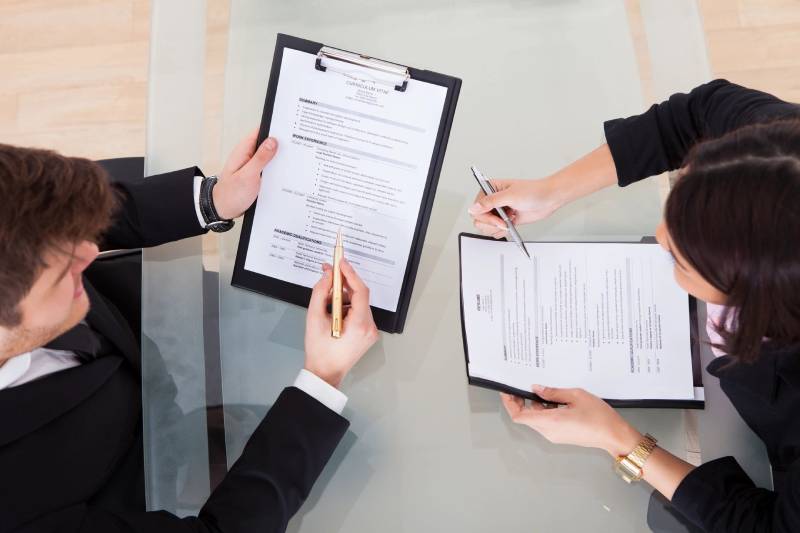 Professionals reviewing resume documents at a table